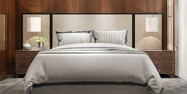 Neatly made bed with tailored headboard and layered pillows, showing how to make a mattress more comfortable.