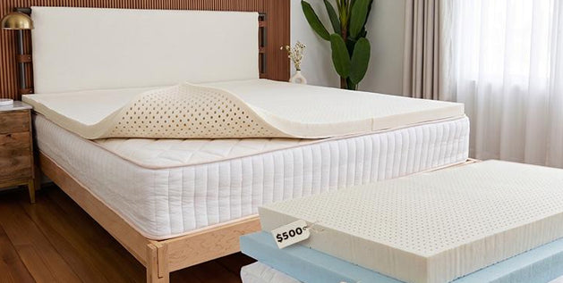 Latex mattress topper on a bed, with stacked topper layers below it on the floor, priced at $50, $250, and $500.