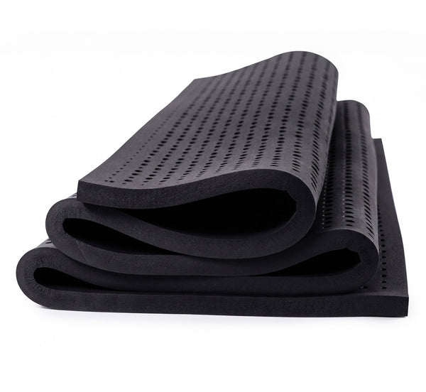 Turmerry Graphite Infused Latex Topper rolled and folded showing perforated dark gray surface with soft edges.